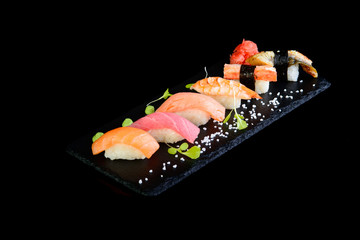 Assorted sushi on a black background with reflection