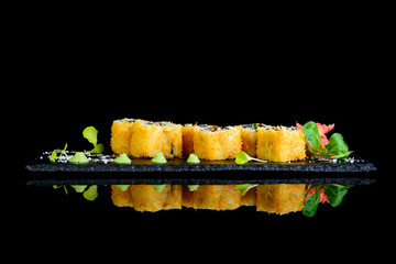 fried roll with eel on a black background with reflection