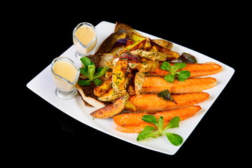 grilled carp and trout with potatoes on black background