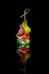 canape salami cucumber on black background with reflection