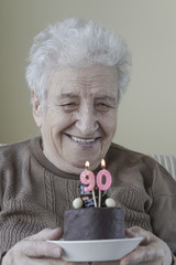 Senior woman with a birthday cake for ninety