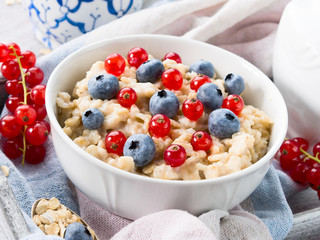 Bowl of oatmeal porridge with blueberries and currants