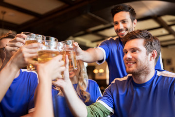 football fans clinking beer glasses at sport bar