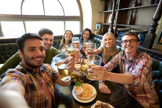 happy friends taking selfie at bar or pub