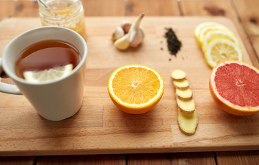 ginger tea with honey, citrus and garlic on wood