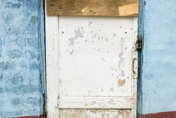 Wooden white beautiful door in an old blue colored building