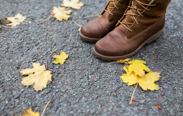 female feet in boots and autumn leaves