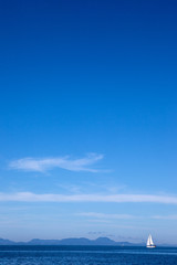 Naklejka premium white yacht traveling at sea against a blue sky