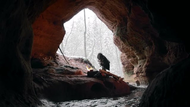 Prehistoric caveman touches snow