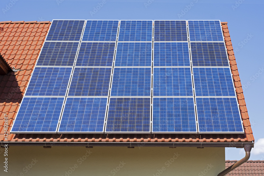 Wall mural solar panels on the red house roof. solar energy background.