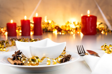 Weihnachtlich, festlich dekorierter Tisch mit Geschirr, Kerzen und Bokehhintergrund