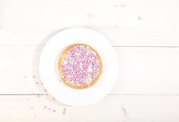 Traditional Dutch birth celebration biscuit with pink muisjes on wooden background