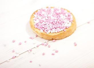 Traditional Dutch birth celebration biscuit with pink muisjes on wooden background