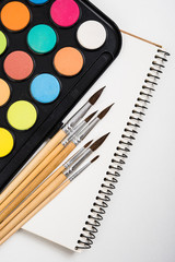 Watercolor paint set and new brushes with clean paper