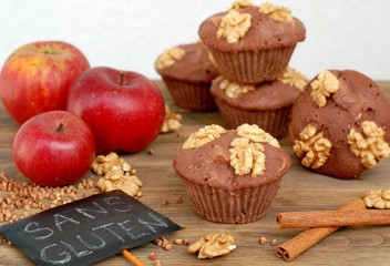 Gluten free muffins from buckwheat flour, apple, cinnamonand walnuts on brown wooden background with index card with text no gluten in french language