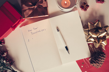 new year resolutions written on notebook with new years decorations