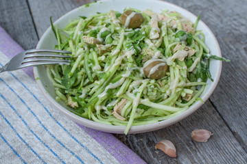 vegan zucchini pasta with tofu, bulgur, green peas, olives and pesto of parsley in a jar. vegetables every day for your health!