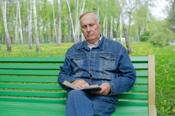 Obraz premium Aged man is reding the book