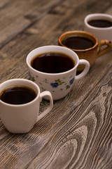 Four cups of coffee on wooden background