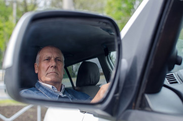 Aged man  sitting in the car
