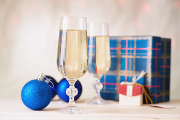 Glasses of champagne with gift boxes and christmas balls 