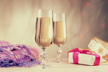 Glasses of champagne with gift box and winter scarf 