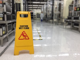 Caution wet floor or cleaning in progress. A yellow sign warning area is being cleaned.