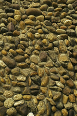 Pebbles stone wall background, closeup view.
