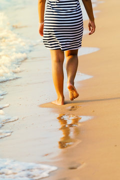 Asian Woman's legs walking on Pattaya sand beach Thailand