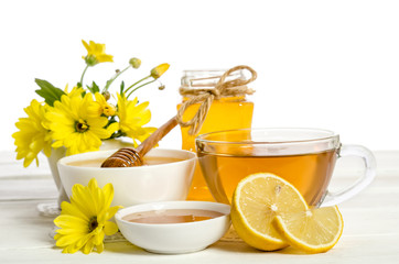 Yellow flowers and honey on wooden table