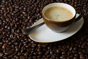 Cup of coffee on beans