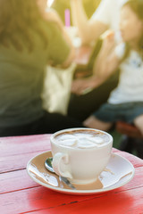 White cup of hot coffee on wood table in coffee shop