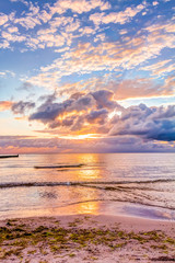 Fototapeta na wymiar Wonderful sunrise with big clouds at the beach in summer