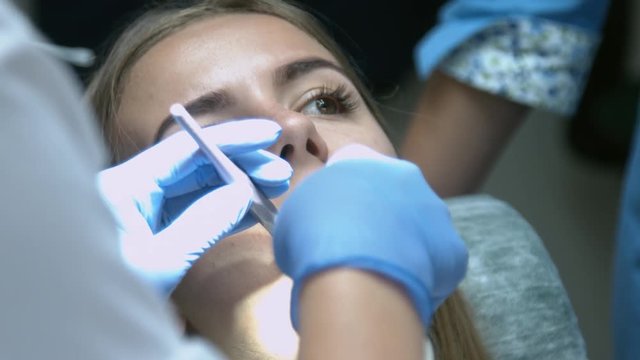 Beautiful girl on the examination by the doctor dentist