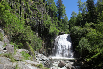 Fototapeta na wymiar Waterfall At wild coast Teletskoe lake, Altai State Natural Bio