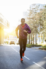 athlete with earphones running in the city