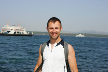 Smiling man standing in the sea port