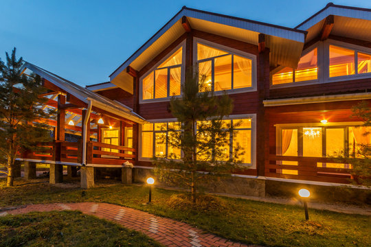 New modern Log Home with Large Porch at dusk