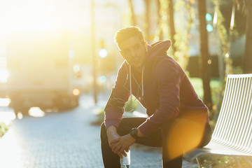 Athlete resting on the bench with bottle of water