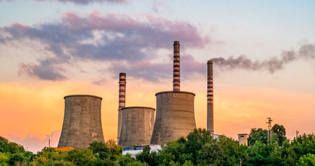 The smoke from the chimneys in the industrial area at the sunset.