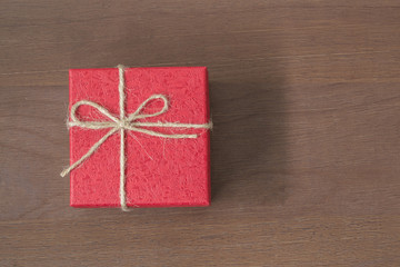 Red gift bow top view on wooden background with copy space.