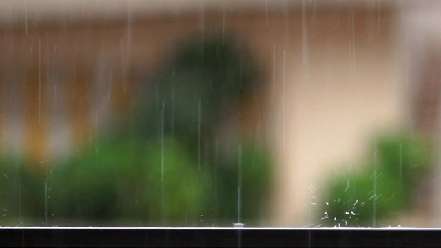 detail of raindrops falling on balcony balustrade and splashes water on slow motion heavy rain