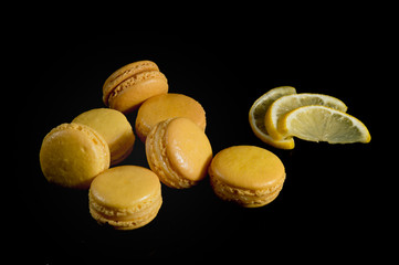 yellow Macaroon with lemon  on a black background shot from above