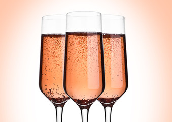 Glass of pink rose champagne with bubbles on pink