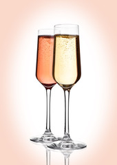 Glasses of pink  and yellow champagne on pink