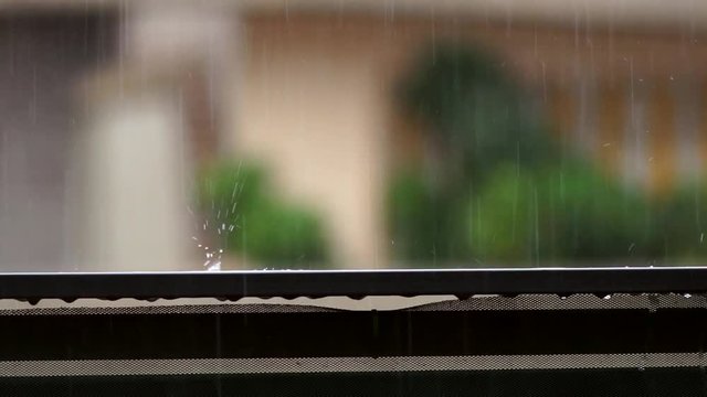 raindrop falling on balcony balustrade and splashes water on slow motion heavy rain