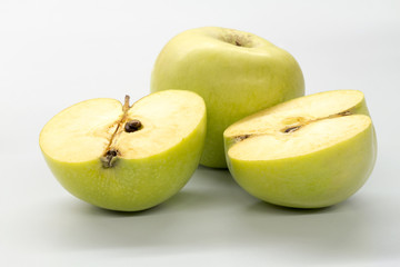 Sliced green apples on a white table.
