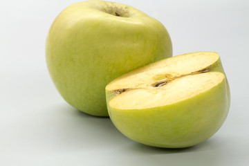 Sliced green apples on a white table.