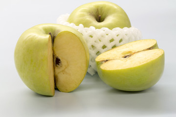 Sliced green apples on a white table.
