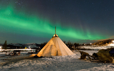 Traditional Sami reindeer-skin tents (lappish yurts) in Troms region of Norway .The polar lights in Norway .